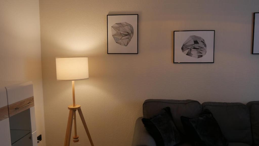 una sala de estar con una lámpara y cuadros en la pared en Ferienwohnung mit Herz in Bautzen en Bautzen