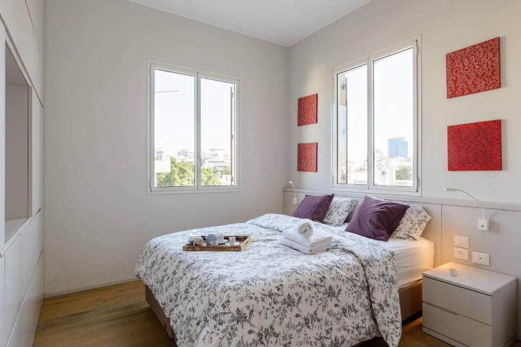 a white bedroom with a bed and two windows at Italian design apartment in Rotchild /habima in Tel Aviv