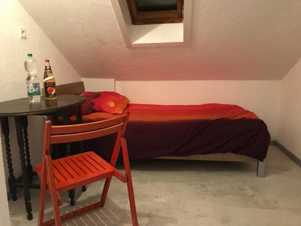 Cozy Room in Ludwigsburg في لودفيغسبورغ: غرفة نوم بسرير وطاولة وكرسي