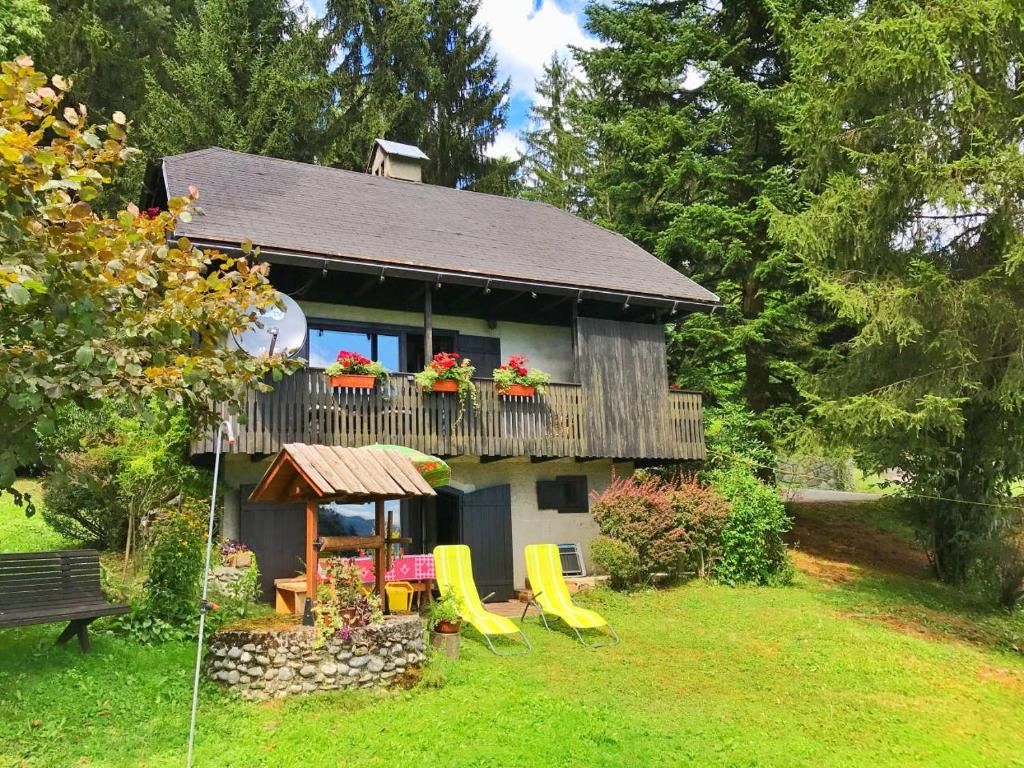 Casa con balcón con sillas y mesa. en Peaceful Nature Cabin Jolly en Mozirje
