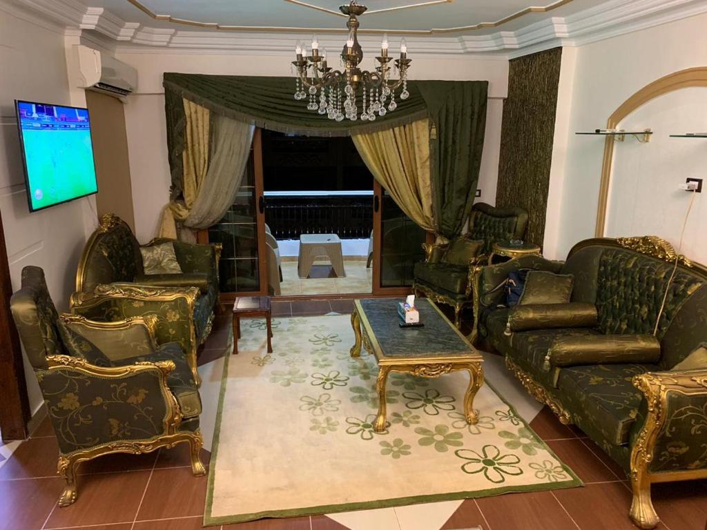een woonkamer met banken en een tafel en een kroonluchter bij mody appartment at alexandria in Alexandrië