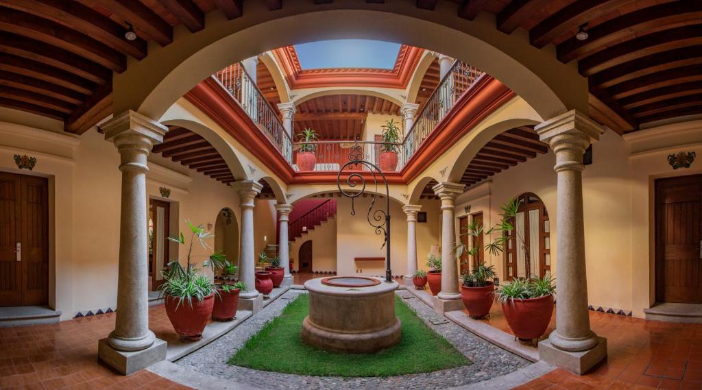 a large hallway with a fountain in the middle of a building at Hotel Casa Barrocco Oaxaca in Oaxaca City