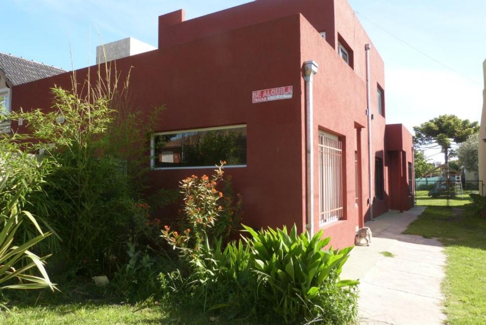 un bâtiment rouge avec un chat assis à l'extérieur dans l'établissement Duplex en Necochea, à Necochea