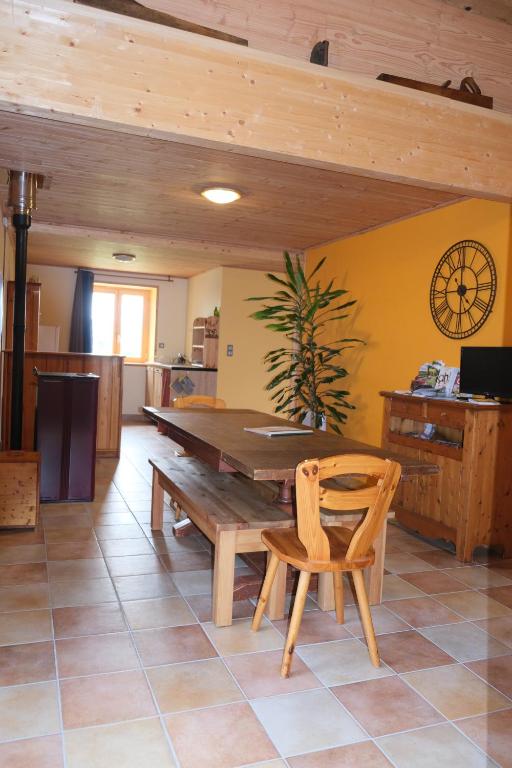 - une salle à manger avec une table et des chaises en bois dans l'établissement Gîte Le Corral, à Cheminas