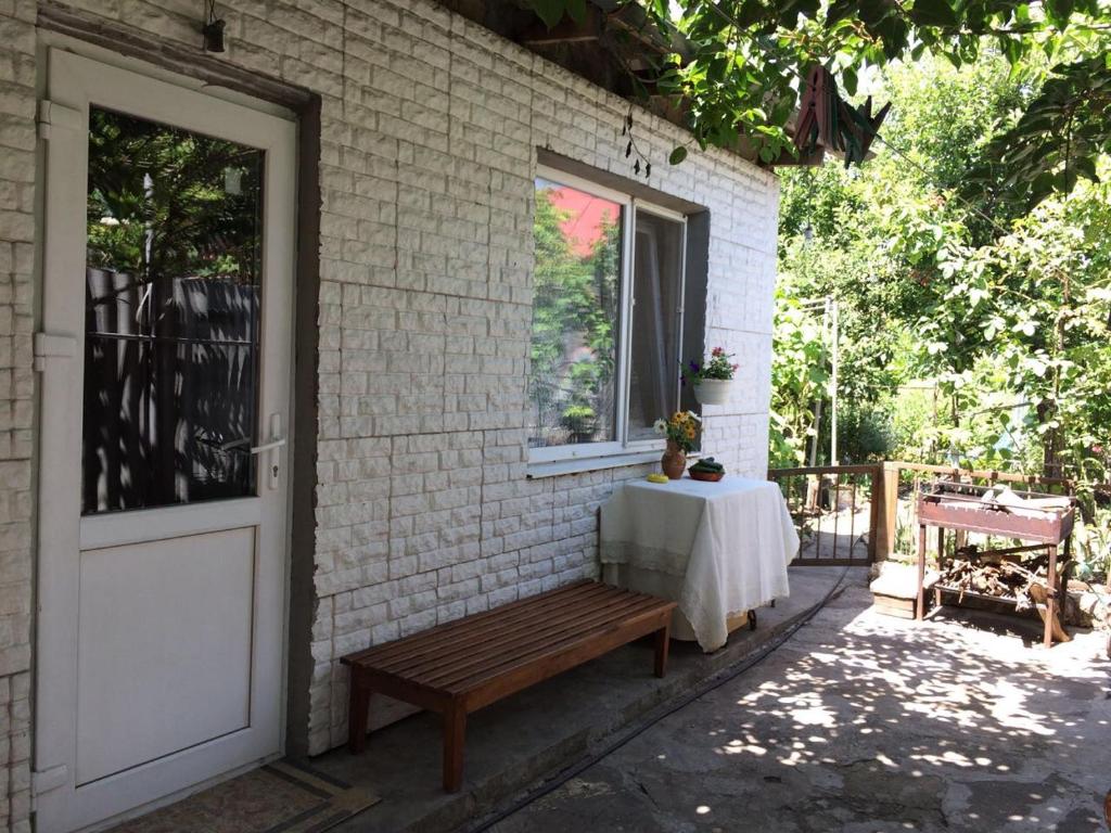 une table assise sur un banc à côté d'une porte dans l'établissement Сдам комнату в гостевом домике, à Odessa