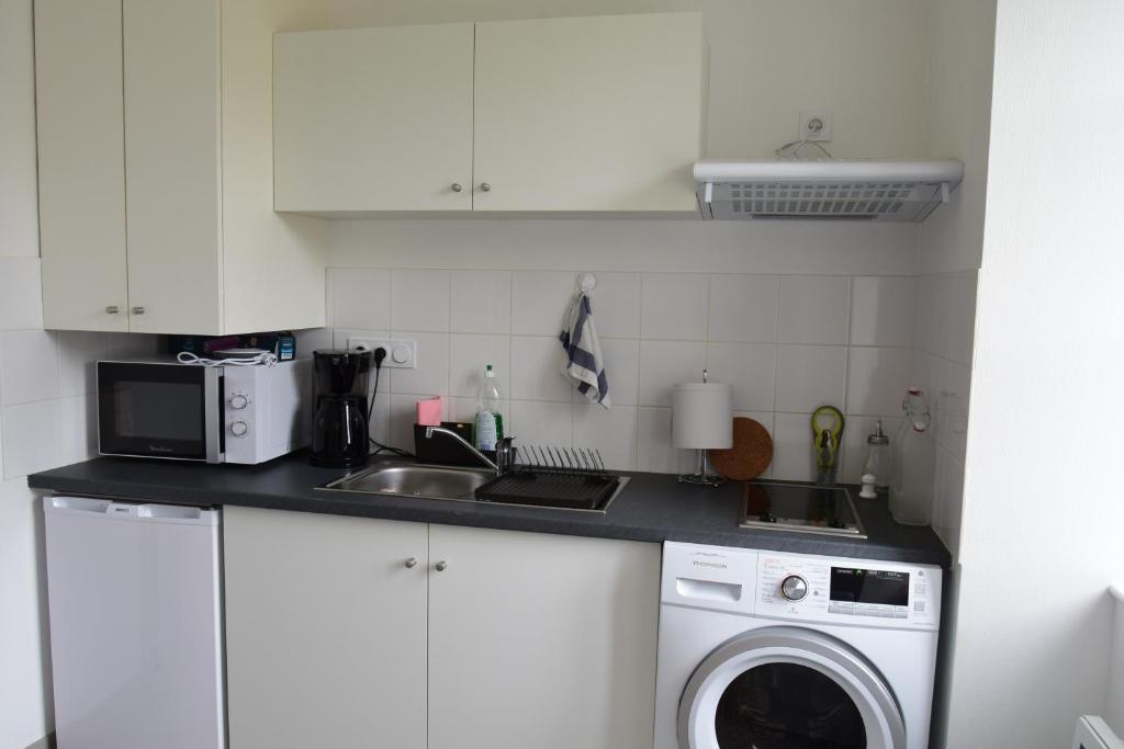 a kitchen with a sink and a washing machine at Maison éclusière Le Port, Les Refuges du Halage in Sacé