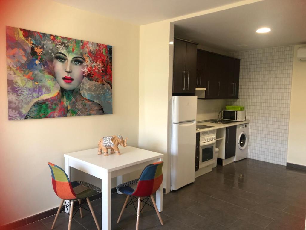 uma cozinha com uma mesa e um quadro na parede em Estudio con piscina y Wifi em Ciudad Real
