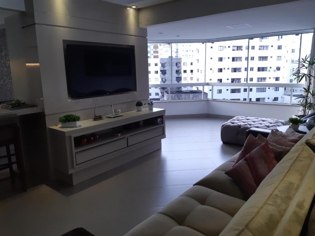 ein Wohnzimmer mit Couch und Flachbildfernseher in der Unterkunft Balneário Camboriú in Balneário Camboriú