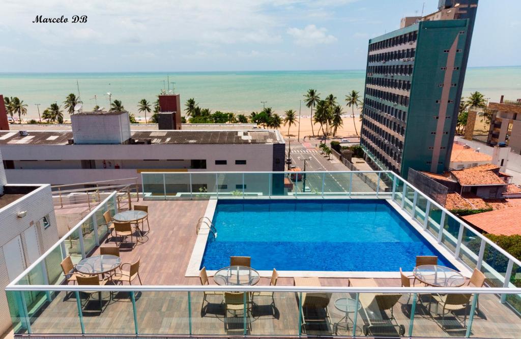 - une vue sur la piscine au-dessus d'un bâtiment dans l'établissement Flat TOP lindo e novo no melhor do Cabo Branco, à João Pessoa