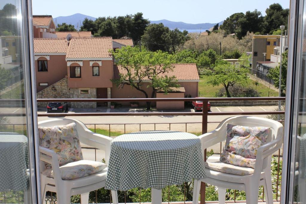 a table and chairs on a balcony with a view at Apartments and rooms Jagoda - comfy and cozy in Zadar