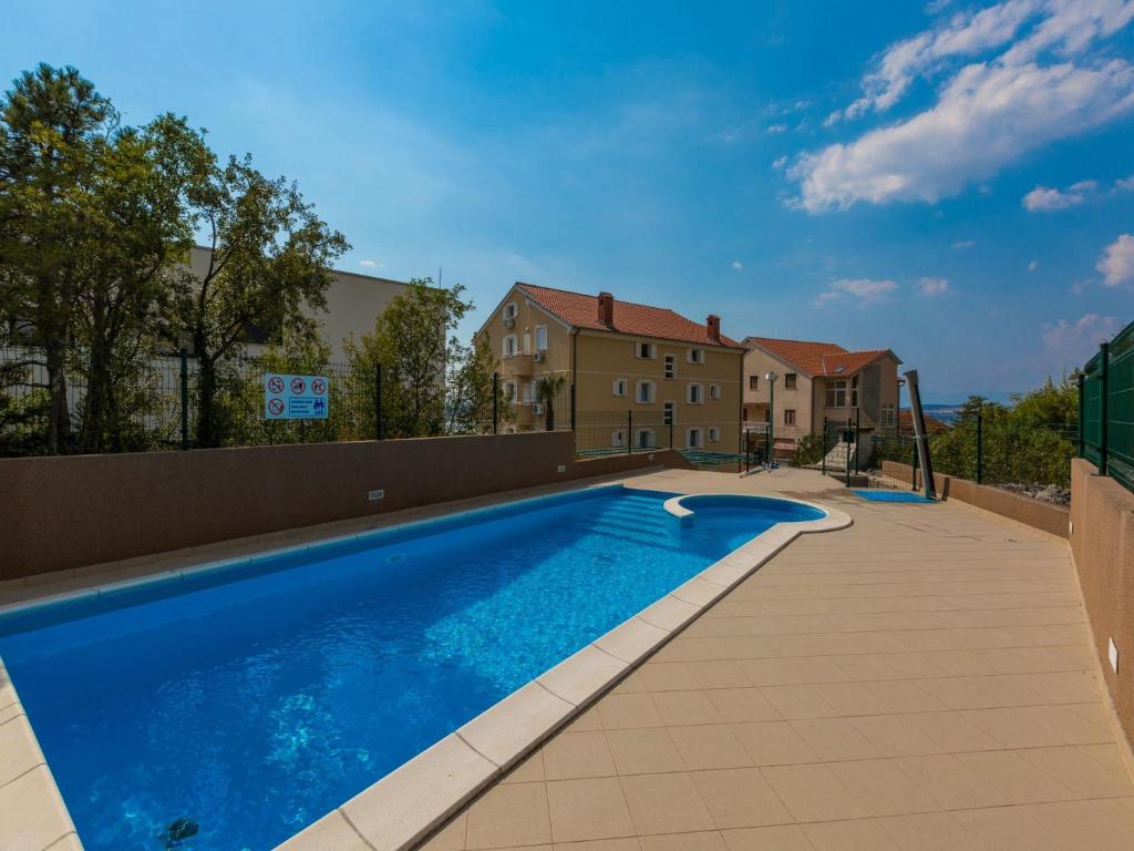 a large blue swimming pool next to a building at Apartments Adria in Dramalj