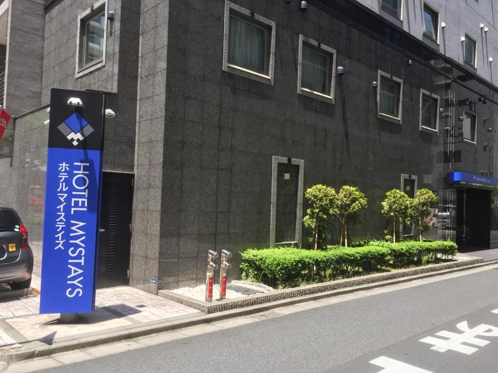a building with a blue sign on the side of a street at HOTEL MYSTAYS Kamata in Tokyo