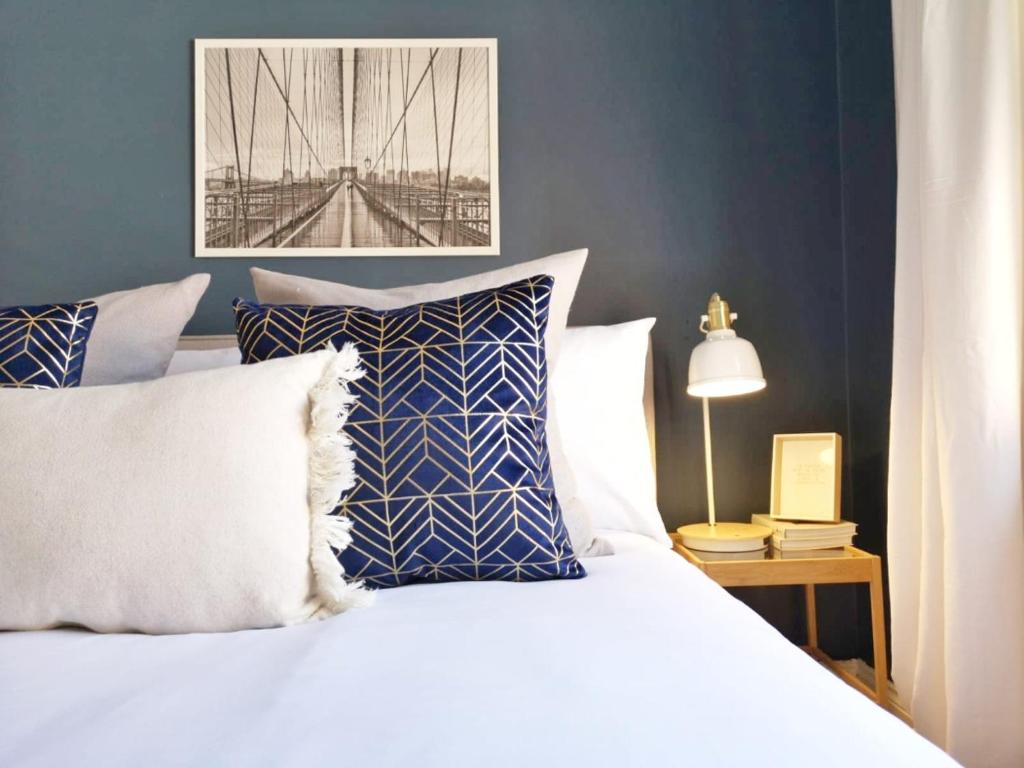 1 dormitorio con 1 cama blanca y paredes azules en Bright, Charming & Peaceful Oxford Apartment, en Oxford