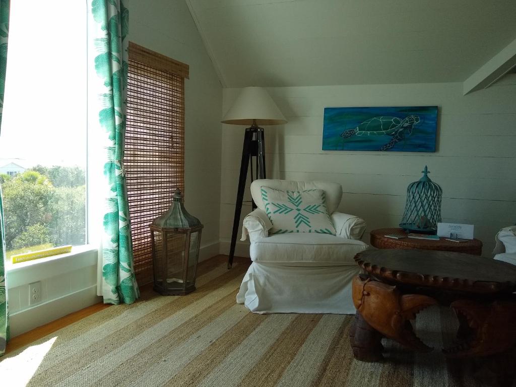 un soggiorno con sedia e finestra di Surf Song Bed & Breakfast a Tybee Island