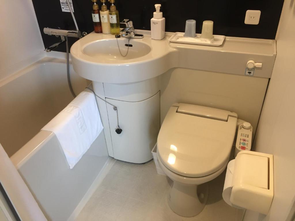 a small bathroom with a toilet and a sink at HOTEL MYSTAYS Kamata in Tokyo