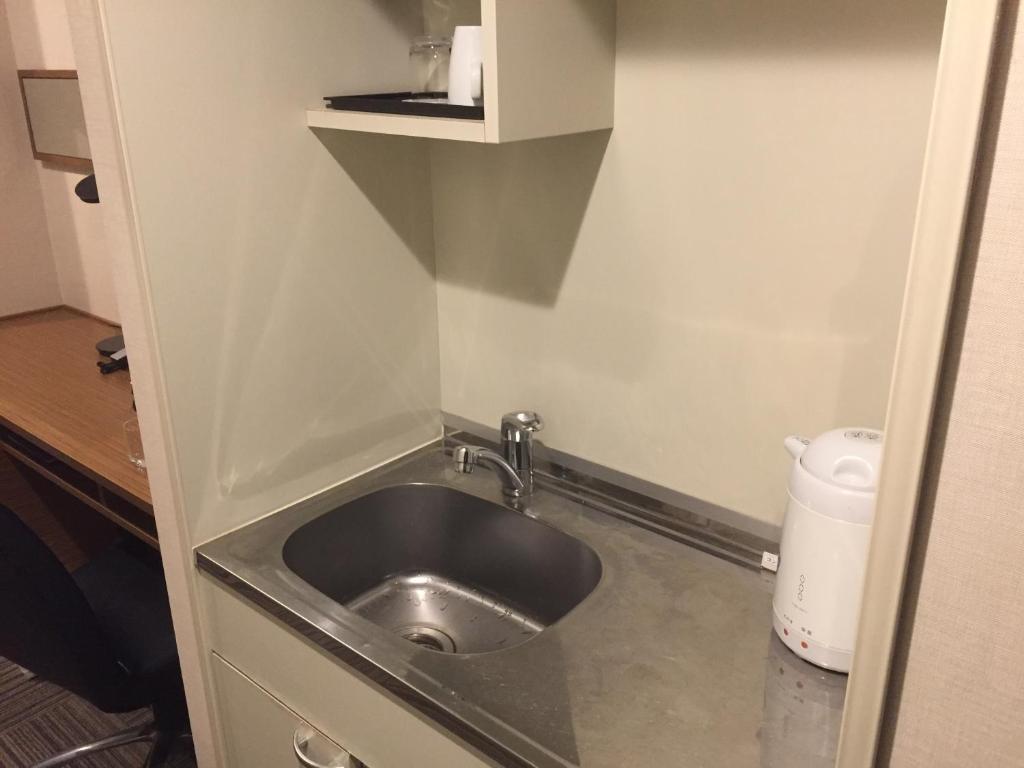 a small bathroom with a sink in a room at HOTEL MYSTAYS Kamata in Tokyo
