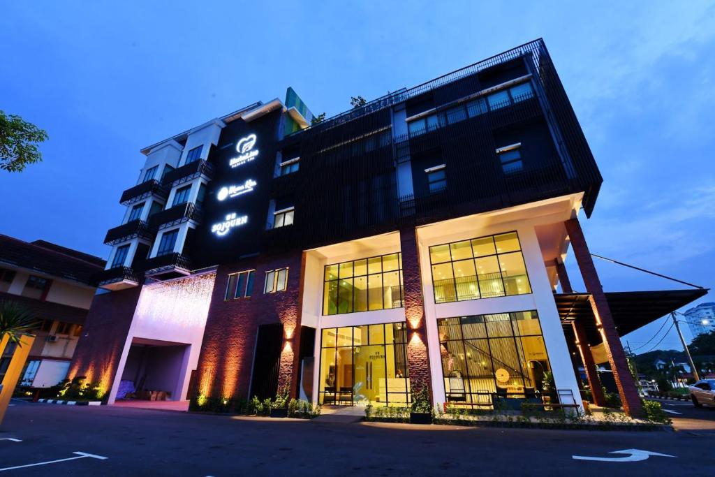 a hotel building with a lit up facade at night at Sojourn Spa Hotel Ipoh in Ipoh