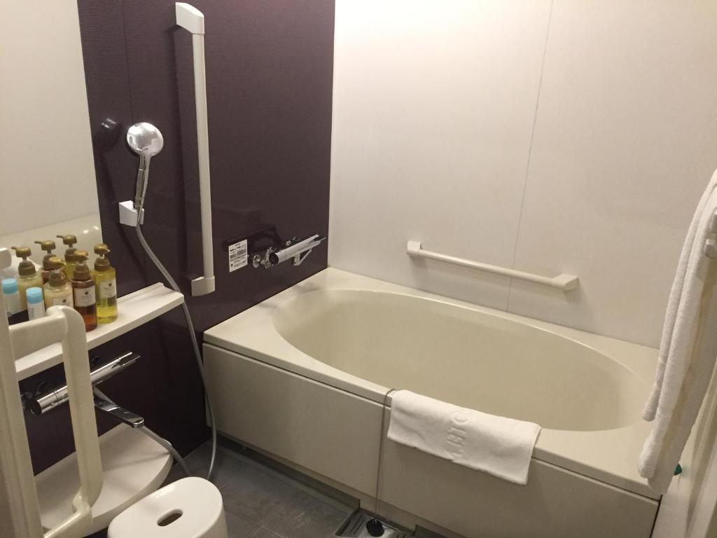 a bathroom with a bath tub and a toilet at HOTEL MYSTAYS Kamata in Tokyo