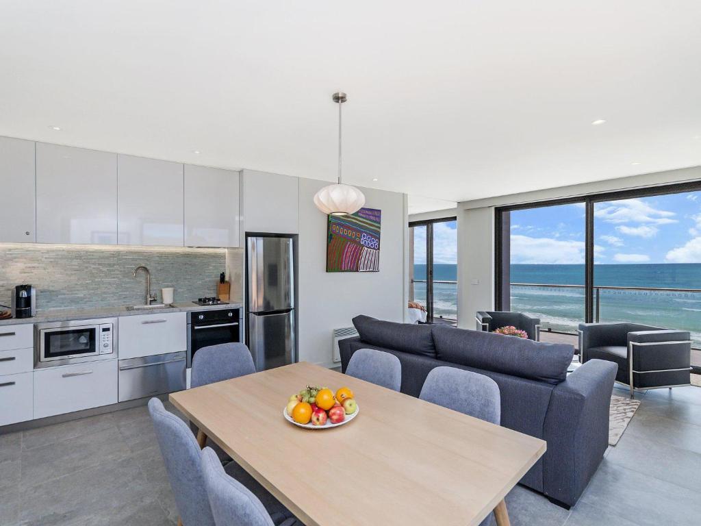 a kitchen and a living room with a table and chairs at Aqua Mist Penthouse in Port Fairy