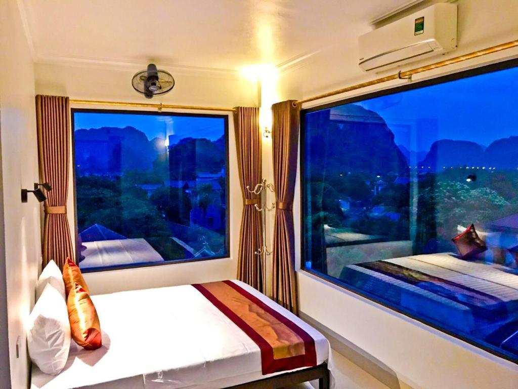 a bedroom with a large window in a train at Trang An Mountain View Homestay in Ninh Binh