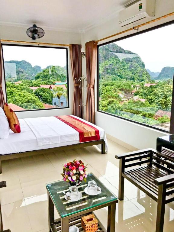 a hotel room with a bed and a large window at Trang An Mountain View Homestay in Ninh Binh
