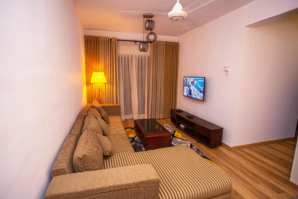 a living room with a couch and a tv at Seabreeze Apartment in Galle