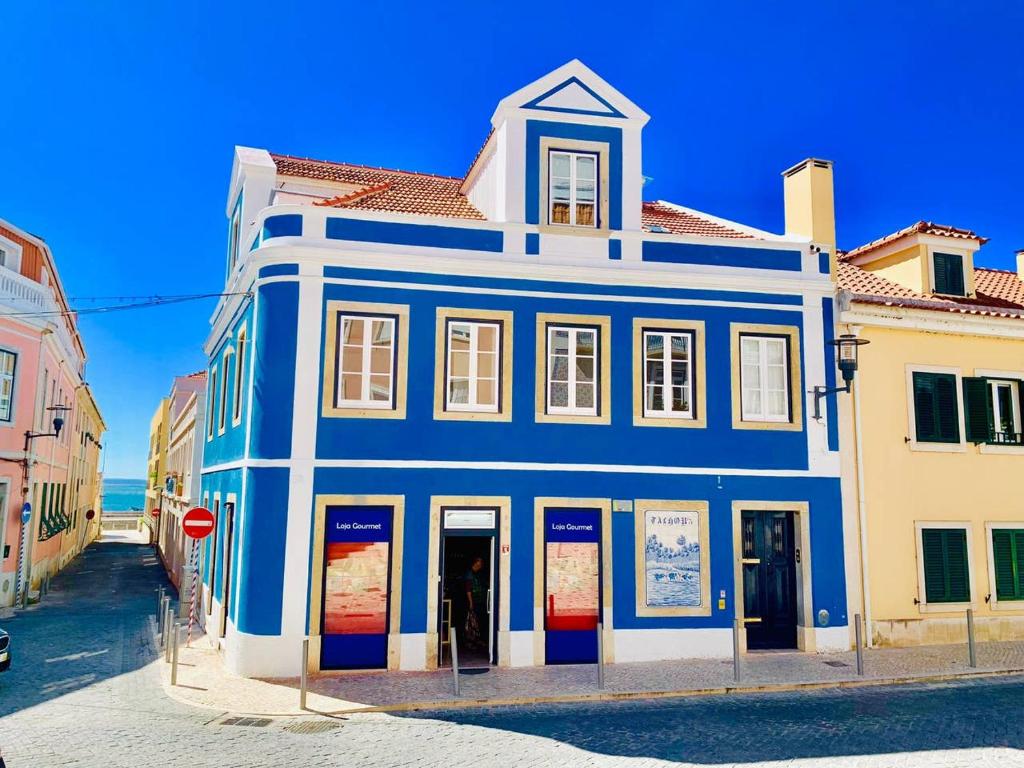 un edificio blu e bianco sul lato di una strada di Best Apartment in Paços de Arcos a Paço de Arcos