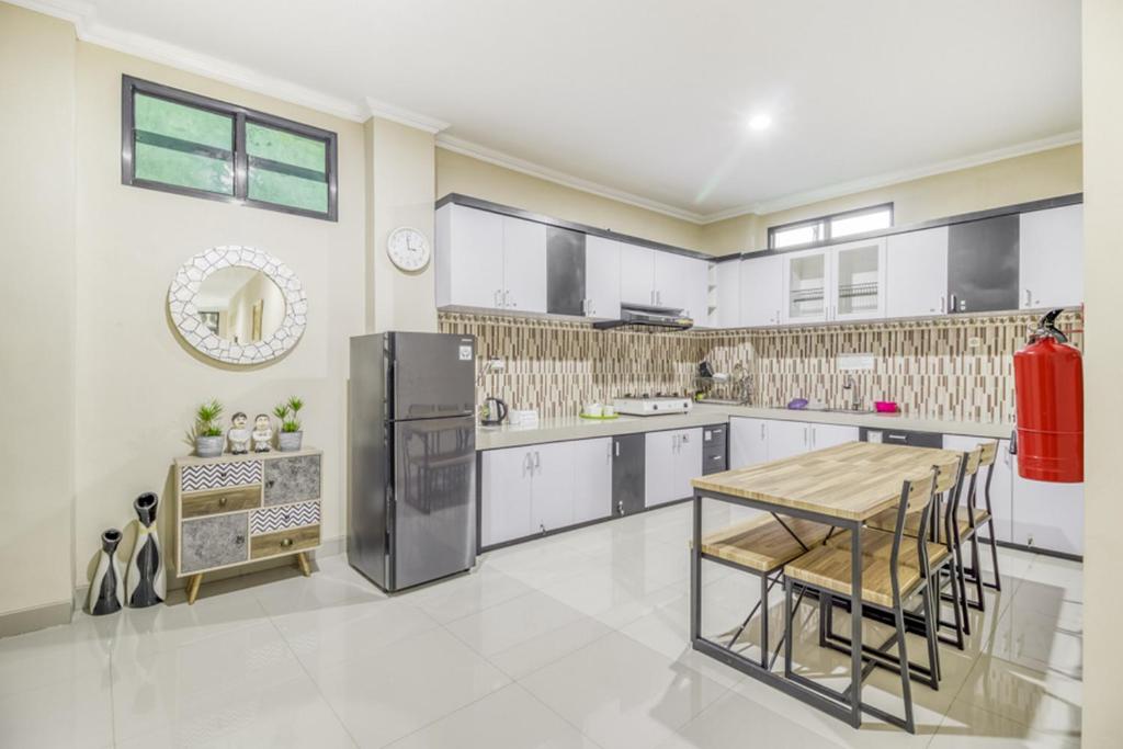 a large kitchen with a table and chairs in it at RedDoorz near Jogja National Museum in Yogyakarta