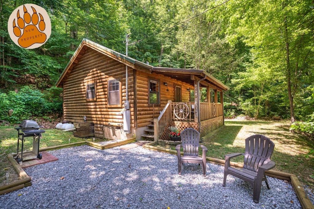 a log cabin with two chairs and a grill at Mosey Bear, Hot Tub, WIFI, 685 FREE tickets each paid day!!! in Sevierville