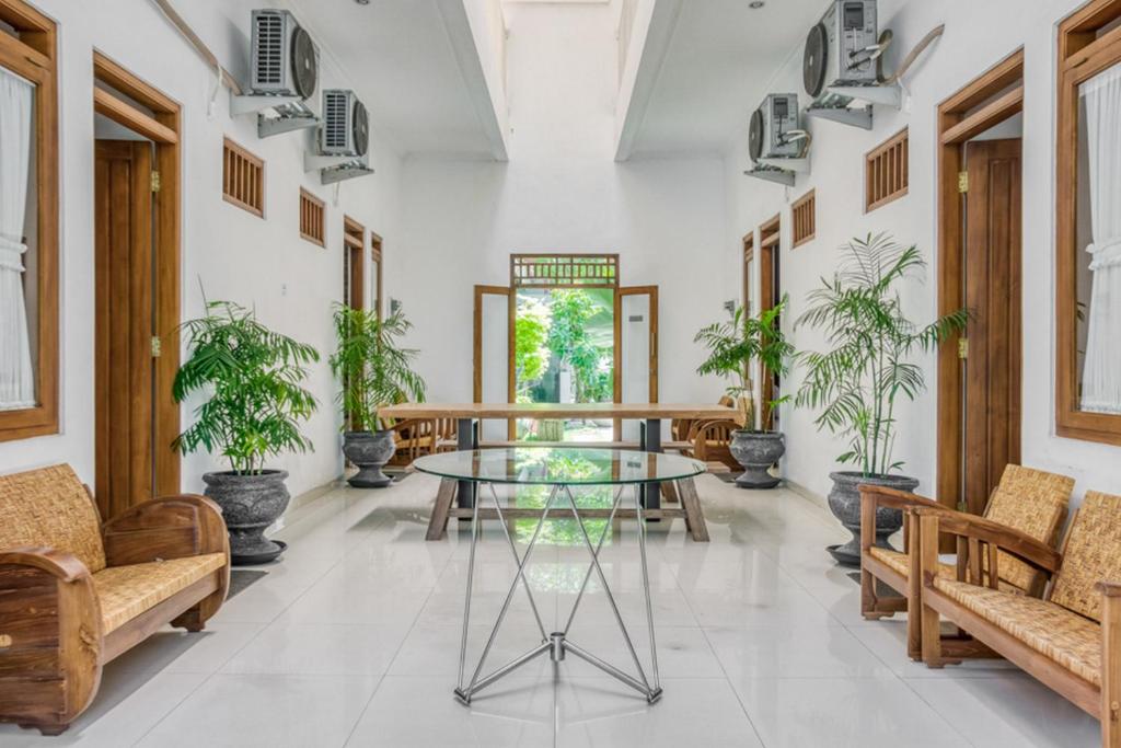 une salle avec des tables, des chaises et des plantes en pot dans l'établissement RedDoorz Syariah near Taman Pelangi Jogja 2, à Yogyakarta