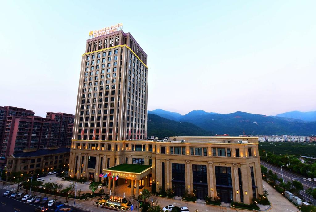 a tall building in front of a city at Ramada Plaza by Wyndham Wenzhou in Wenzhou