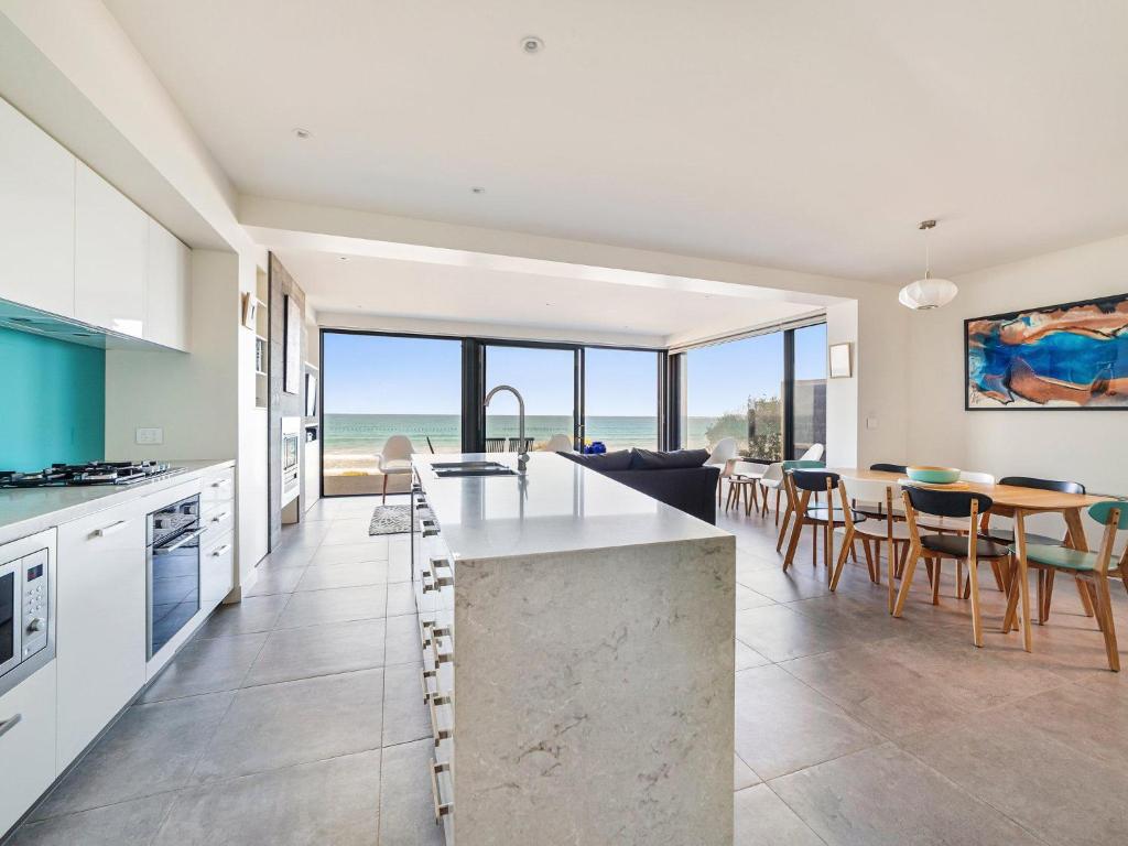 a kitchen and dining room with a view of the ocean at Aqua Mist Seascape in Port Fairy