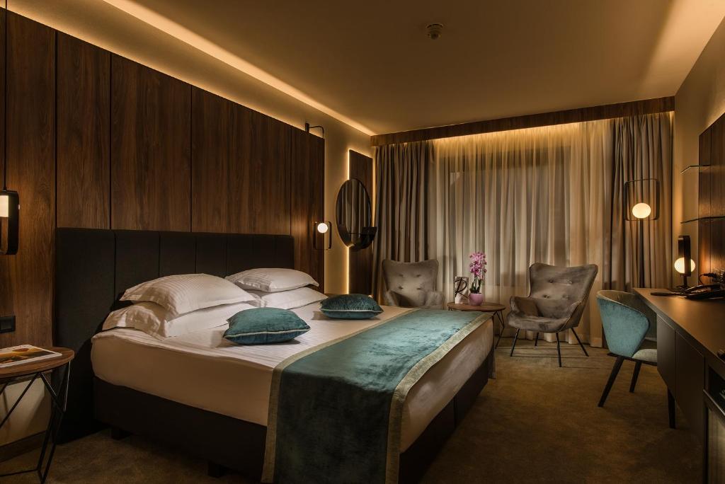 una camera d'albergo con un grande letto e una scrivania di Rosslyn Central Park Hotel Sofia a Sofia