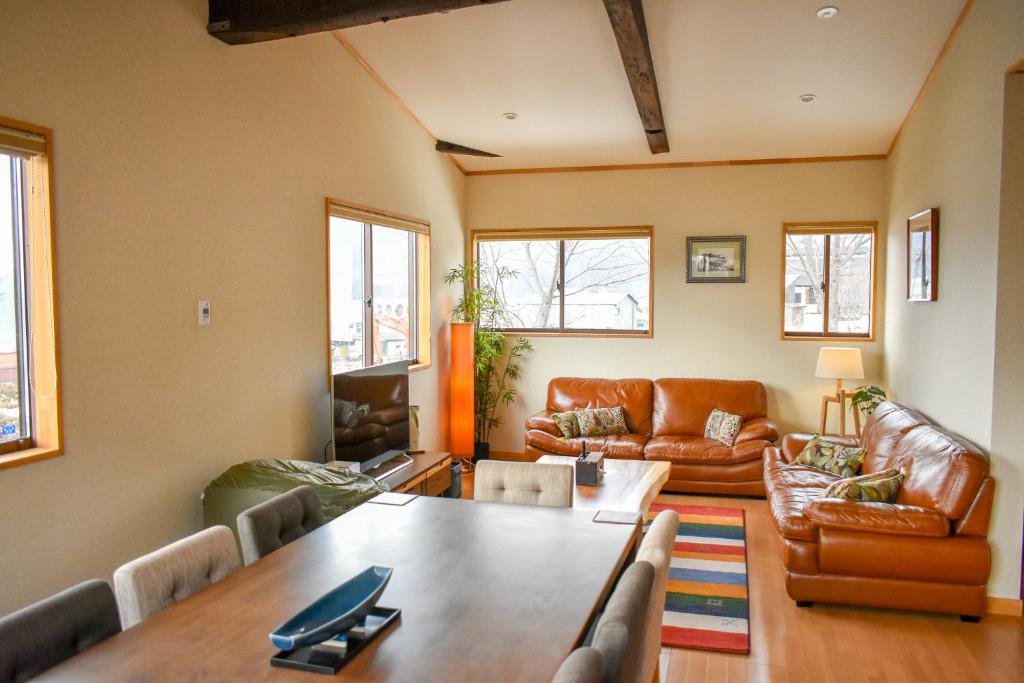 uma sala de estar com uma mesa e mobiliário de couro em Holiday Home Nozawa em Nozawa Onsen