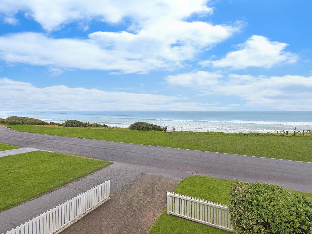 a road leading to the beach with a white fence at Blue Vista in Port Fairy