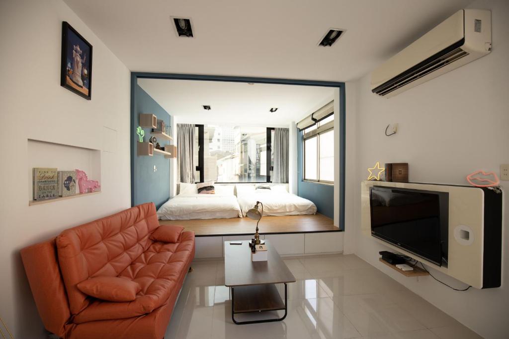 1 dormitorio y sala de estar con sofá y TV. en YouI98 Guesthouse一層一戶大坪數套房#本國旅客須先匯款, en Tainan