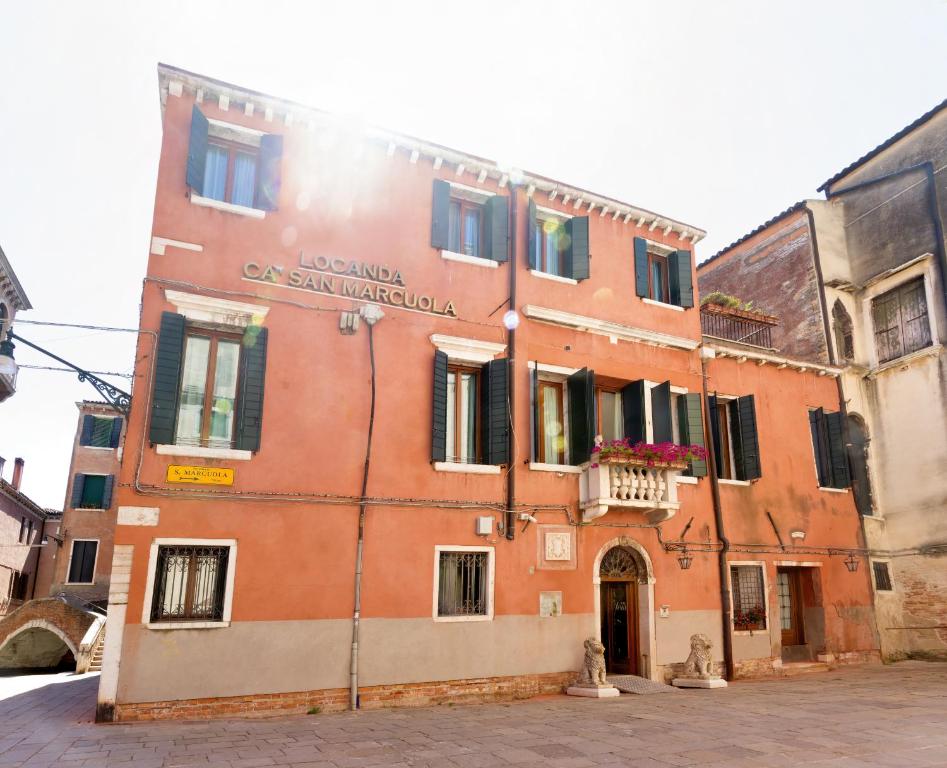 an orange building with a balcony on a street at Guesthouse Ca' San Marcuola 1 in Venice