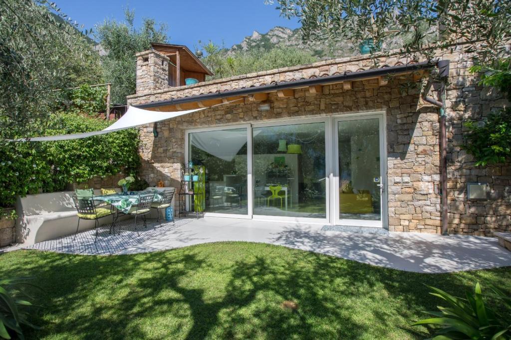 a stone house with a patio and a lawn at Patty's Lemonhouse in Limone sul Garda