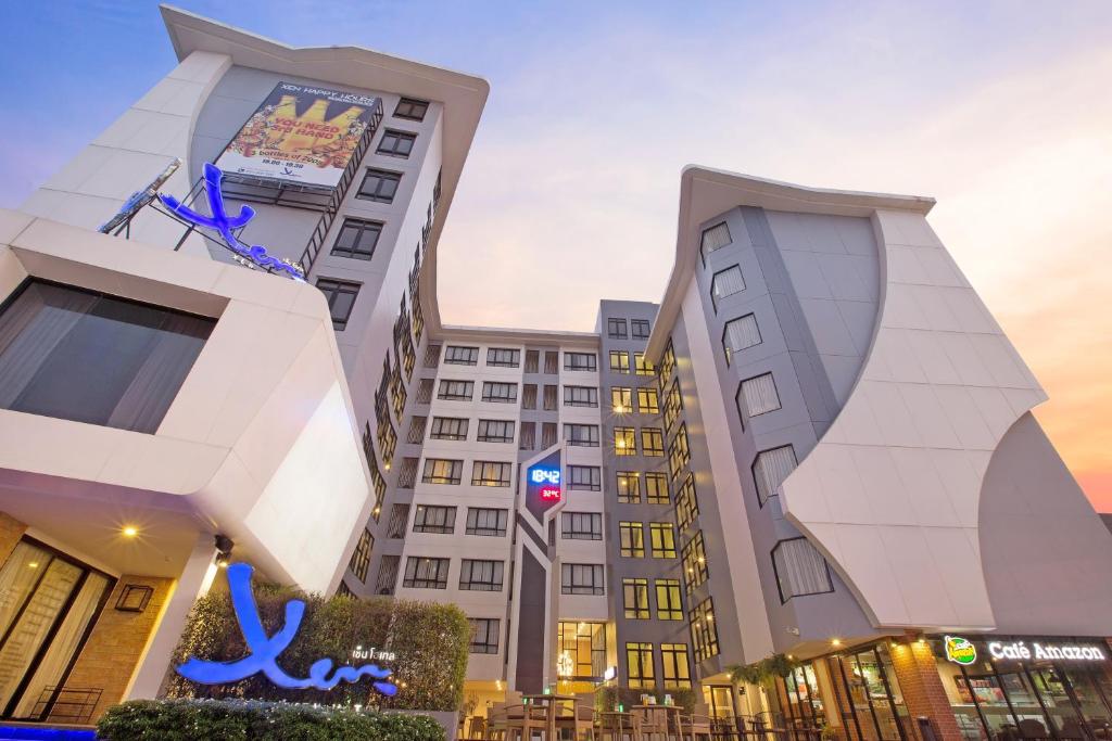 a tall white building with a sign on it at Xen Hotel Nakhon Pathom - SHA PLUS in Nakhon Pathom