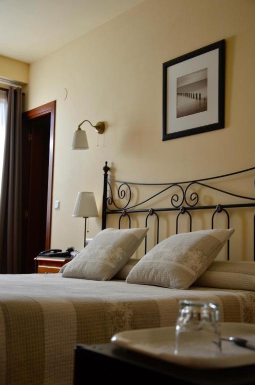 a bedroom with a bed with a table and a picture on the wall at Hotel Alameda in Zarautz