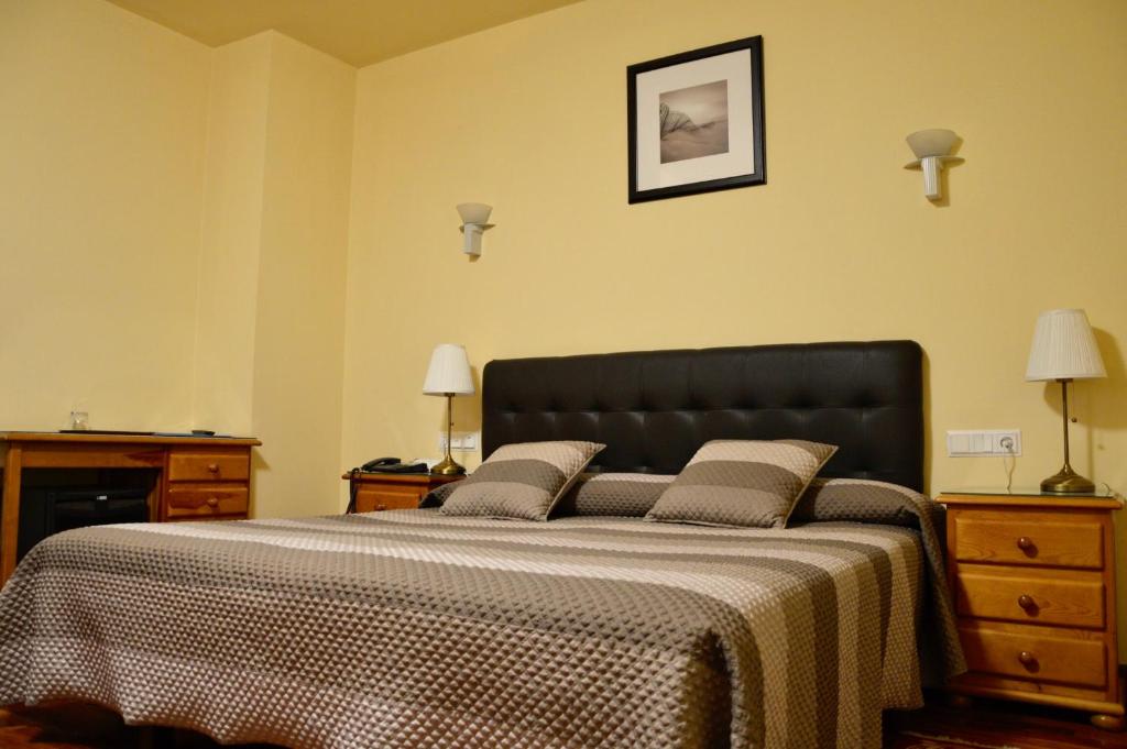 a bedroom with a large bed with a black headboard at Hotel Alameda in Zarautz