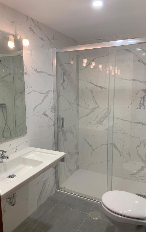 a bathroom with a shower and a toilet and a sink at Hotel Alameda in Zarautz