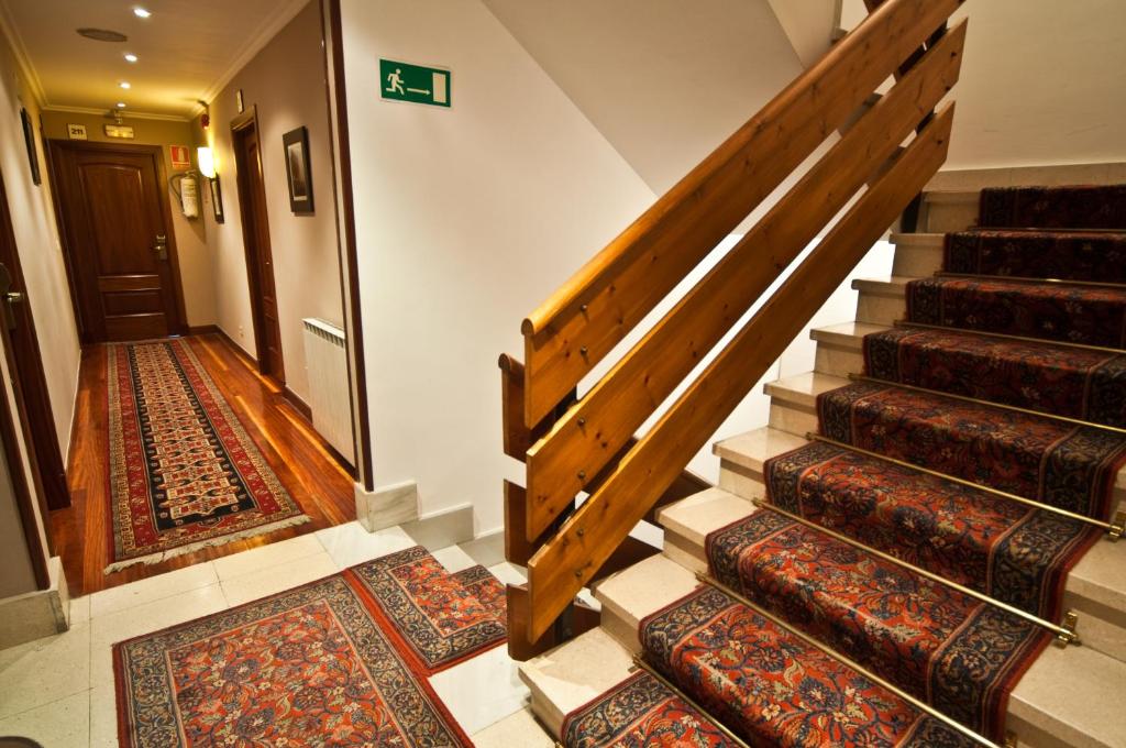 a hallway with carpeted stairs with rugs at Hotel Alameda in Zarautz
