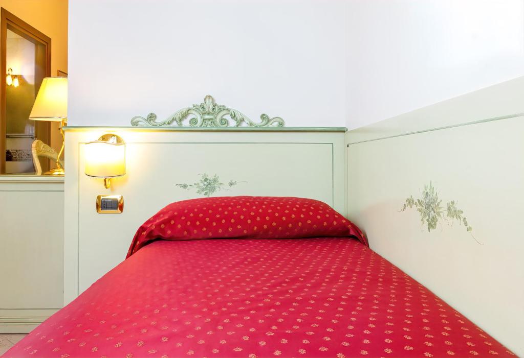 a red bed in a white room with a red bedspread at Guesthouse Ca&#39; San Marcuola 1 in Venice
