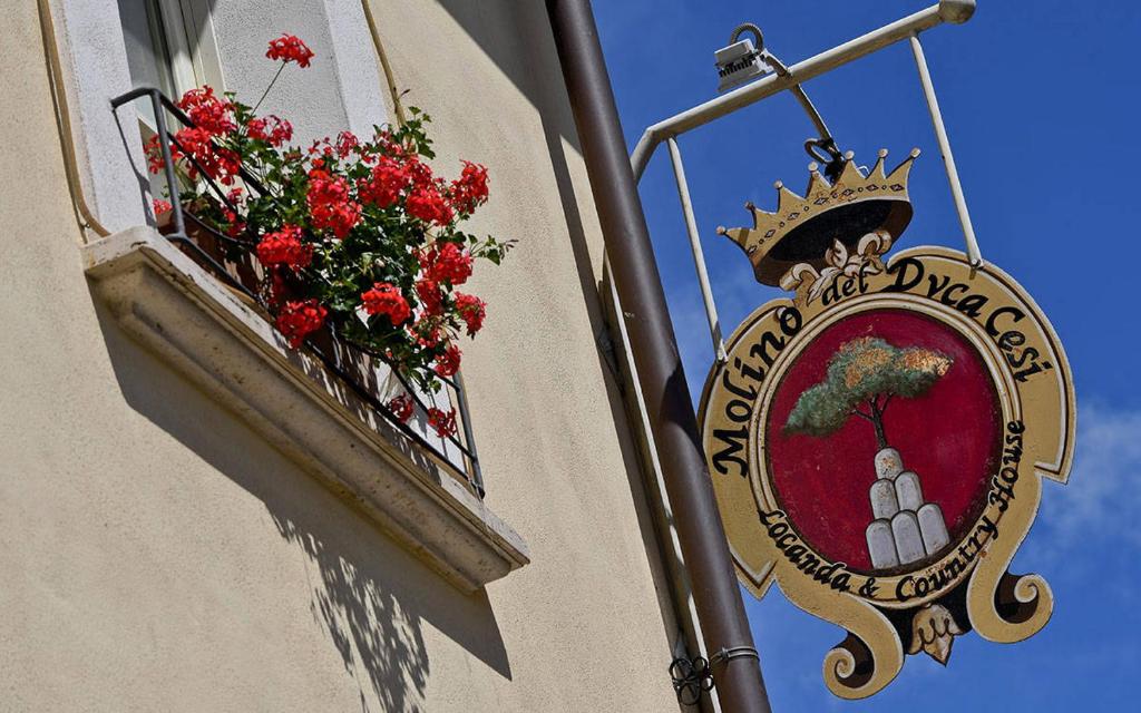una señal en el lateral de un edificio con una caja de flores en Molino Del Duca Cesi, en Terni