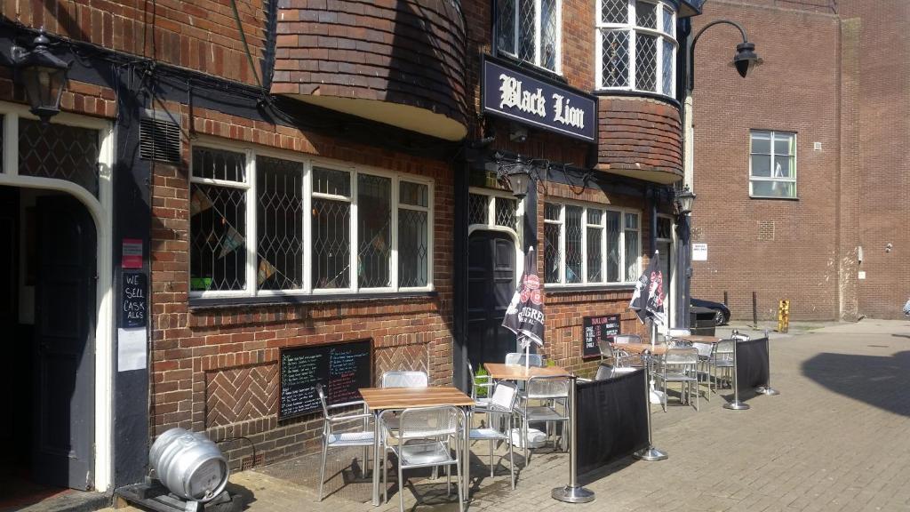 a brick building with tables and chairs outside of it at Black Lion in Scarborough
