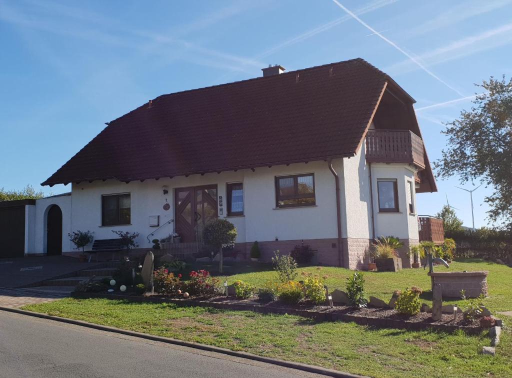 a white house with a black roof at Ferienwohnung Frischkorn in Steinau an der Straße