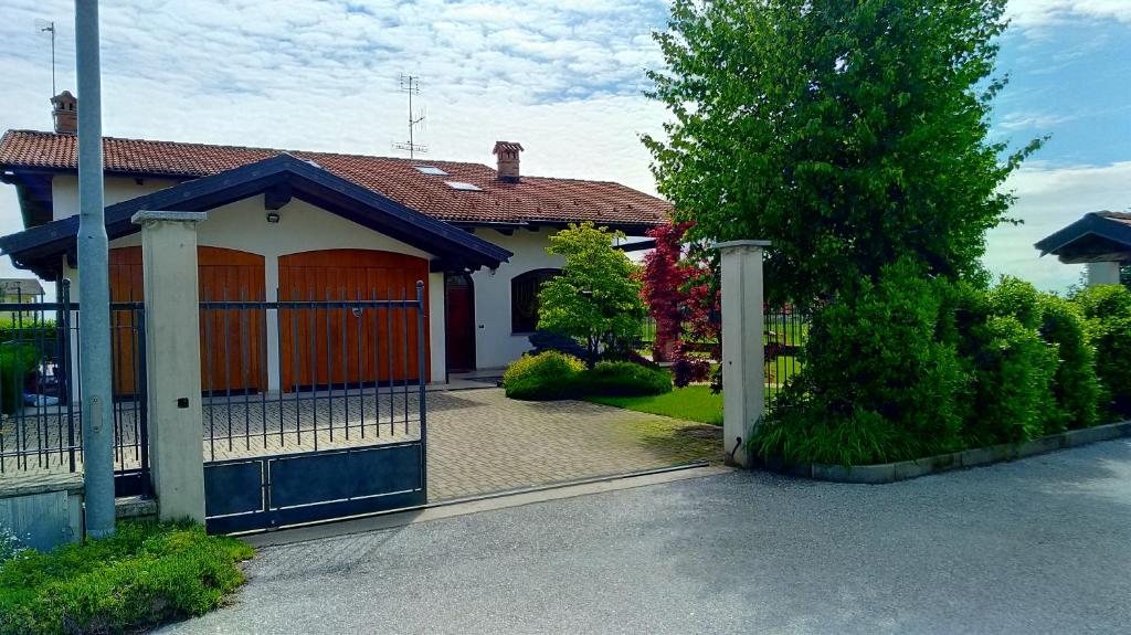 a house with a blue gate and a tree at Nel Verde in Villar San Costanzo
