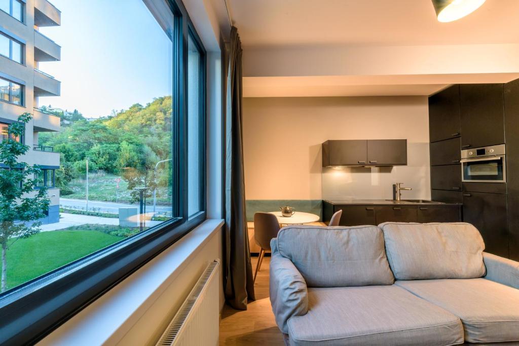 a living room with a couch and a large window at Bratislava center, river front, private parking included in Bratislava