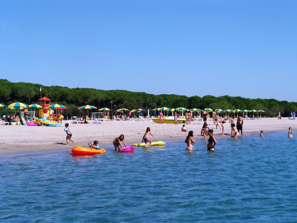 a group of people in the water at the beach at Happy Camp mobile homes in Camping Thurium Villaggio in Marina di Sibari